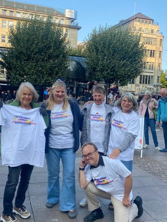 4 Frauen und ein junger Mann in weißen t-Shirts mit der Aufschrift gemeinsam leben gemeinsam lernen